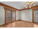 Dining room featuring hardwood-look vinyl floors, wood beam accents, and doors to the outside at 6141 Madison Ave, Indianapolis, IN 46227