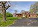 Traditional home with a brick accent, covered porch, driveway, and mature trees at 6141 Madison Ave, Indianapolis, IN 46227