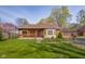 Cozy home with brick accents, a covered porch, and a well-manicured lawn at 6141 Madison Ave, Indianapolis, IN 46227