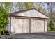 Close up of a two car garage with carriage doors and exterior lights at 6141 Madison Ave, Indianapolis, IN 46227