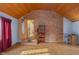 Bright living room featuring a brick accent wall, wood-paneled ceiling, and hardwood flooring at 6141 Madison Ave, Indianapolis, IN 46227