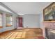 Sun-filled room featuring hardwood floors, a brick fireplace, and updated windows at 6141 Madison Ave, Indianapolis, IN 46227