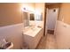 Bathroom featuring a vanity with white cabinets, sink, mirror, and tiled walls at 6144 S Irwin St, Indianapolis, IN 46237