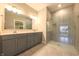 Modern bathroom featuring double vanity with gray cabinets, tile flooring, and a glass-enclosed shower at 6222 Fairview Dr, McCordsville, IN 46055