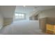 Expansive bonus room with dormered ceiling, neutral carpet, large window, and staircase at 6222 Fairview Dr, McCordsville, IN 46055