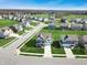 Aerial view showcases homes in a peaceful neighborhood with lush green lawns and mature trees at 6767 Sonora Blvd, Brownsburg, IN 46112