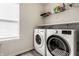 Bright laundry room with a large window, washer, dryer and overhead storage shelves at 6767 Sonora Blvd, Brownsburg, IN 46112