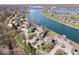 Scenic aerial shot of townhomes on a lake, featuring garages and lush landscaping at 7454 Harbour Isle # 158, Indianapolis, IN 46240