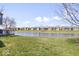 Expansive grassy backyard with a serene pond view and community buildings beyond at 7454 Harbour Isle # 158, Indianapolis, IN 46240
