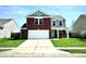 Inviting two-story home featuring a brick facade, attached two-car garage, and well-maintained lawn at 8051 Retreat Ln, Indianapolis, IN 46259