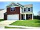 Inviting two-story home featuring a brick facade, attached two-car garage, and well-maintained lawn at 8051 Retreat Ln, Indianapolis, IN 46259