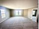 Spacious living room featuring large windows, neutral walls, and new carpet flooring at 8051 Retreat Ln, Indianapolis, IN 46259