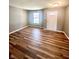 Neutral room showcasing wood flooring, a window for natural light, and a simple white front door at 8051 Retreat Ln, Indianapolis, IN 46259