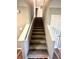 Carpeted staircase leading to the upper level of the house with white railings and neutral colored walls at 8051 Retreat Ln, Indianapolis, IN 46259