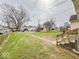 Spacious backyard featuring green lawn and mature trees, offering ample space for outdoor activities at 831 Wallace Ave, Indianapolis, IN 46201