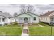 Charming home featuring a well-maintained lawn and a delightful lattice-covered front porch at 831 Wallace Ave, Indianapolis, IN 46201