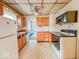 A kitchen featuring wood cabinets, a white refrigerator, laminate countertops, and vinyl flooring at 831 Wallace Ave, Indianapolis, IN 46201