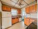 A kitchen featuring wood cabinets, a white refrigerator, laminate countertops, vinyl flooring, and black appliances at 831 Wallace Ave, Indianapolis, IN 46201