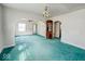 A living room with green carpet, white walls, multiple windows, and an archway leading to the kitchen at 831 Wallace Ave, Indianapolis, IN 46201