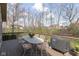 Outdoor deck area features a table and chairs and grill with a wooded backdrop at 8939 Spider Bay Ct, Indianapolis, IN 46236