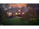 Stunning two-story brick home featuring a manicured lawn and mature landscaping under a dramatic, colorful sunset at 8939 Spider Bay Ct, Indianapolis, IN 46236