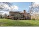 Well-maintained home featuring a large sunroom addition, deck, mature trees, and lawn at 8939 Spider Bay Ct, Indianapolis, IN 46236