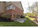 Exterior view of home featuring a brick facade, multiple windows, and a small patio area at 8939 Spider Bay Ct, Indianapolis, IN 46236