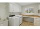 Bright laundry room with white cabinets, washer, dryer, folding counter and tile flooring at 8939 Spider Bay Ct, Indianapolis, IN 46236