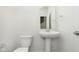 Stylish half bathroom with a pedestal sink, modern fixtures, and a clean, white aesthetic at 9738 Behner Dr, Fishers, IN 46250