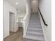 Bright entryway featuring hardwood floors, stairs with carpet runner, and a view into the kitchen at 9738 Behner Dr, Fishers, IN 46250