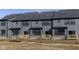 Rear view of townhomes featuring dark siding and a patio area at 9738 Behner Dr, Fishers, IN 46250