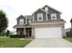 Charming two-story home with a brick and gray siding, a covered porch and a well-manicured front yard at 981 Redwood Dr, Franklin, IN 46131