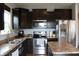 Kitchen featuring stainless steel appliances, dark cabinets, and stone countertops at 981 Redwood Dr, Franklin, IN 46131