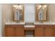 Bathroom features a double vanity with matching mirrors, lots of lighting, and a center dressing table at 9877 Wading Crane Ave, Fishers, IN 46055