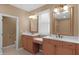 Bright bathroom features a double vanity with matching mirrors, lots of lighting, and an open doorway at 9877 Wading Crane Ave, Fishers, IN 46055