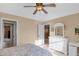 Bedroom view with ensuite access, ceiling fan, white doors, and lots of light at 9877 Wading Crane Ave, Fishers, IN 46055
