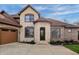 Grand entrance featuring stone accents, arched doorway and a three-car garage at 9877 Wading Crane Ave, Fishers, IN 46055