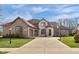 Stunning two-story brick home with a three-car garage, basketball hoop, and lush green lawn at 9877 Wading Crane Ave, Fishers, IN 46055