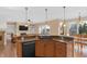 Modern kitchen with granite countertops, wooden cabinets, and stainless steel dishwasher overlooking the living area at 9877 Wading Crane Ave, Fishers, IN 46055