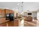 Spacious kitchen with wooden cabinets, granite countertops, and modern appliances adjacent to living area at 9877 Wading Crane Ave, Fishers, IN 46055