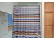 Bathroom area featuring a striped shower curtain and towel racks mounted next to wooden cabinets at 102 E Thompson St, Lebanon, IN 46052