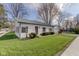 Charming home with white siding, red trim, a metal roof, and a well-manicured lawn at 102 E Thompson St, Lebanon, IN 46052