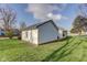 White home featuring white siding, a dark roof, well-manicured lawn, and curb appeal at 102 E Thompson St, Lebanon, IN 46052