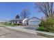 View of single-story home with a detached garage, fenced yard, and a metal roof at 102 E Thompson St, Lebanon, IN 46052