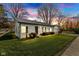 Charming home with a metal roof, well-manicured lawn, and a detached garage during a colorful sunset at 102 E Thompson St, Lebanon, IN 46052