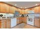 Well-equipped kitchen featuring oak cabinets, white appliances, and practical layout at 102 E Thompson St, Lebanon, IN 46052