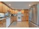 Functional kitchen with oak cabinets, white appliances, and ample counter space at 102 E Thompson St, Lebanon, IN 46052