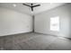 Minimalist bedroom with gray carpet, a modern ceiling fan, and natural light from a large window at 1026 St Peter St, Indianapolis, IN 46203