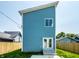 Striking modern home with light blue siding, bright white trim, and a contemporary single-pane window above the entryway at 1026 St Peter St, Indianapolis, IN 46203