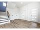 Bright foyer with wood-look flooring, stairs with iron railing, and contemporary white doors, offering a welcoming space at 1026 St Peter St, Indianapolis, IN 46203